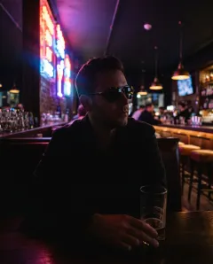 Photo to skip: a man in sunglasses in a dim bar